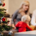 A cozy family gathering by the Christmas tree, enjoying festive decorations.
